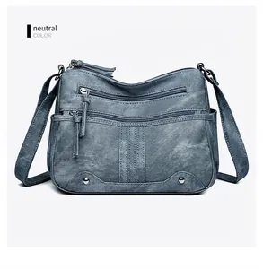 Sac bandoulière rétro bleu montrant la texture vintage et les poches zippées superposées