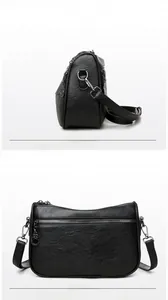 Detail view of black faux leather crossbody bag showing side profile and back zipper pocket