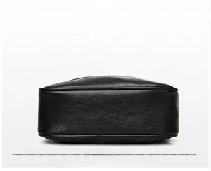 Detailed bottom view of black leather crossbody bag showing neat stitching and lychee texture
