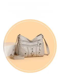 Detail view of woven leather crossbody bag with multiple zippers and metal rivets