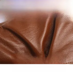 Close-up of soft dark brown leather texture with natural grain for woven crossbody bag
