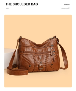 Detail of deep brown woven leather crossbody bag featuring multiple functional zippers