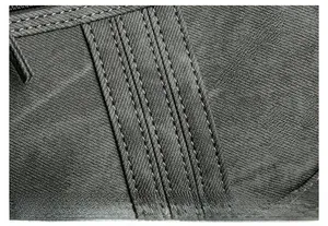 Détail du tissu tissé gris anthracite résistant avec des coutures renforcées sur le sac