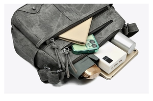 Détail d'un sac bandoulière gris à grande capacité avec compartiments pour tablette et accessoires