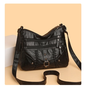 Detail of black woven crossbody bag featuring three front zippers and vintage soft leather