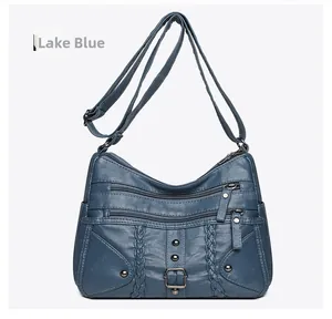 Lake Blue woven crossbody bag featuring three front zipper pockets and silver rivets