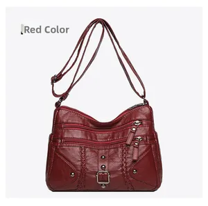 Detail of red woven shoulder bag with multiple zippers and soft leather texture