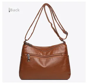 Detailed back view of a vintage brown leather woven crossbody bag with zipper pocket