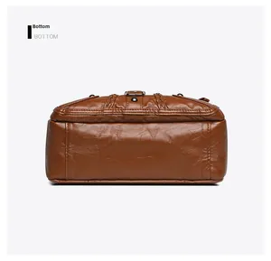Detail view of the durable bottom stitching on this soft woven brown leather crossbody bag