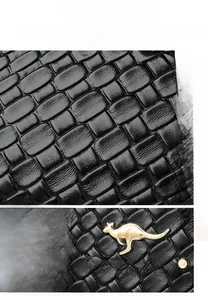 Close-up of black crossbody bag featuring gold kangaroo logo and woven leather texture