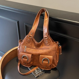 Retro brown pebbled faux leather tote bag with functional pockets on a black leather chair