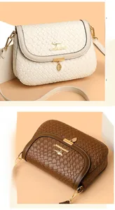 Detail of woven texture faux leather handbags with kangaroo logo and leaf pendant