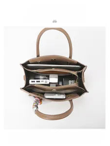 Top view of brown leather tote showing spacious interior with iPad and daily essentials