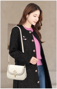 Detail of white crocodile texture leather crossbody bag with gold kangaroo emblem logo
