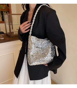 Close-up of silver sequin handbag with thick braided shoulder strap on model in cafe