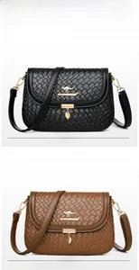 Detail of woven texture shoulder bags in black and brown with leaf pendants