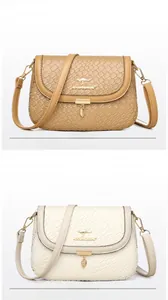 Detail of woven texture handbag with golden kangaroo logo and leaf pendant accessory