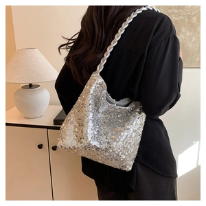 Detail of silver sequined handbag featuring a unique metallic braided shoulder strap