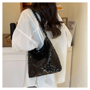 Detail of black sequined hobo bag featuring a unique braided rope shoulder strap on model