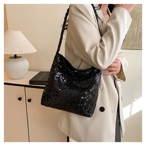 Detailed view of black sequined shoulder bag featuring woven rope strap on a model