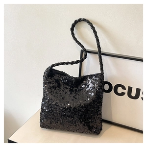 Detail of black sequin shoulder bag with textured woven rope strap on minimalist background