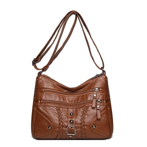 Brown woven crossbody bag with three front zippers and adjustable shoulder strap