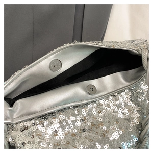 Detail of silver sequin handbag showing secure double magnetic closures and black lining