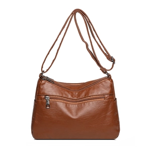 Brown woven leather crossbody bag with multiple zip pockets and adjustable shoulder strap