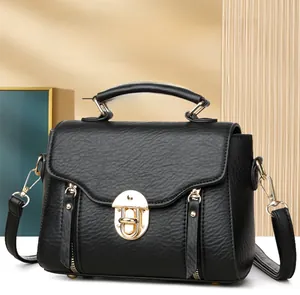 Close-up of black litchi pattern leather bag featuring elegant golden metal lock hardware