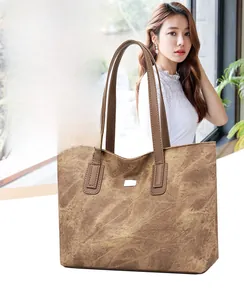 Detail view of large brown tote bag with slightly waterproof texture and metal decor