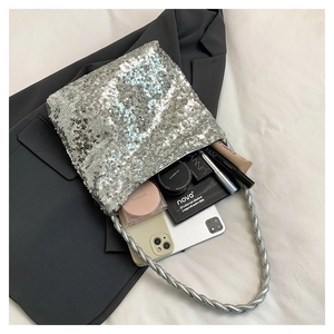 Detail view of silver sequin handbag interior showing spacious capacity for cosmetics