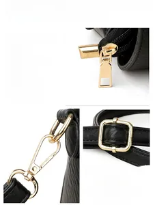 Close-up of golden metal zipper and hardware on black litchi pattern leather bag