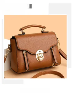 Detail of caramel leather square handbag featuring golden lock and texture stitch
