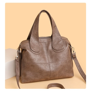 Detail of vintage brown tote bag with cross-stitch pattern and silver metal hardware