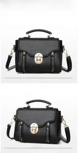 Detail view of black PU leather crossbody bag with gold hardware and top handle strap