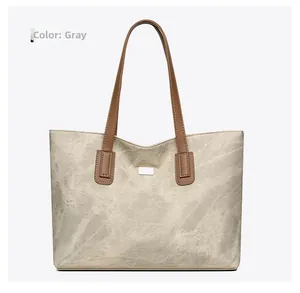 Detail view of the durable grey canvas tote bag with brown faux leather handles