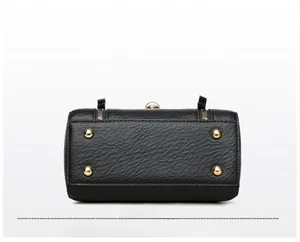 Detail view of the black lychee pattern leather bag base with gold metal feet studs