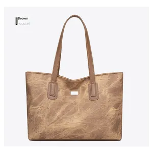 Close-up of vintage brown leather tote bag showing detailed texture and stitching