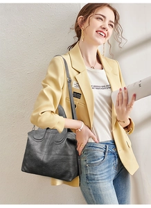 Lifestyle shot of large black lychee texture leather tote bag with adjustable strap