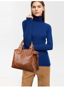 Brown retro tote bag in lychee leather grain with wide handle shown with a model