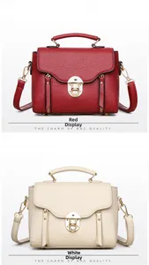Detail view of burgundy and cream crossbody bags with metal locks and decorative zippers