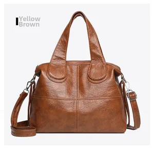 Detail of yellow brown vintage PU leather handbag with silver hardware and dual handles