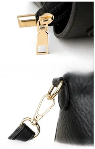 Detail of premium gold-tone zipper and metal strap hooks on a black leather square bag