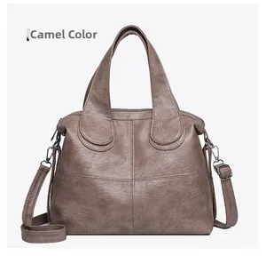 Detail view of camel leather tote bag with cross stitching and adjustable strap