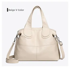 Detail view of cream white soft leather handbag with cross stitching and metal zippers