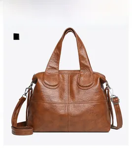 Vue de face d'un sac à main marron en cuir grainé avec coutures croisées et bandoulière