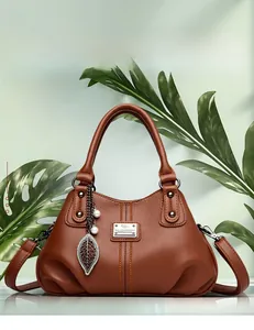 Detail view of brown lychee grain leather tote with leaf pendant and kangaroo logo plate
