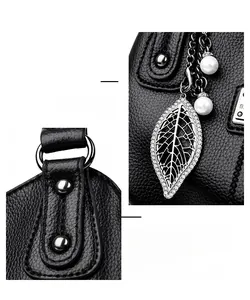 Close-up of black litchi texture leather handbag with leaf pendant and pearl charms