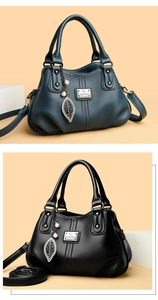 Close-up of litchi grain texture handbag with leaf pearl pendant and metal logo detail