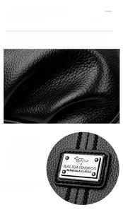 Close-up of black litchi grain leather texture and polished silver brand metal plaque